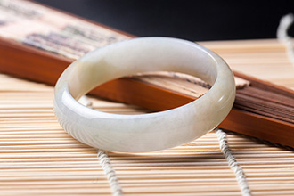 Jade Bracelet on Chinese Fan & Bamboo Mat